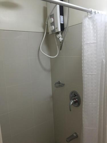 a bathroom with a shower with a shower curtain at Bella Suites at Wind Residences Tagaytay in Tagaytay