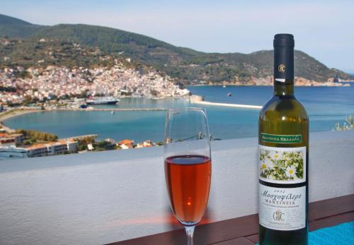 a glass of wine sitting next to a bottle of wine at Irene' s Paradise in Skopelos Town