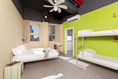 a room with two bunk beds and a ceiling fan at Abraham Tel Aviv in Tel Aviv