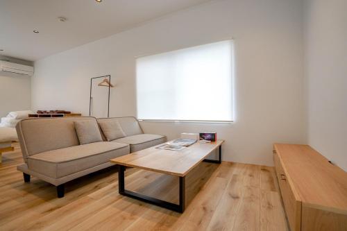 a living room with a couch and a coffee table at 果実の見える宿 in Koshu