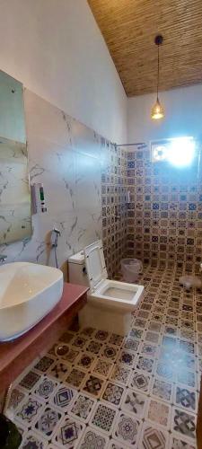 a bathroom with a sink and a toilet in it at Eeja Resto and Cafe in Garappu