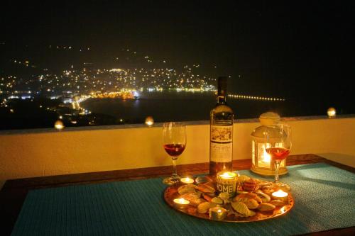 a bottle of wine and two glasses on a table with candles at Irene' s Paradise in Skopelos Town