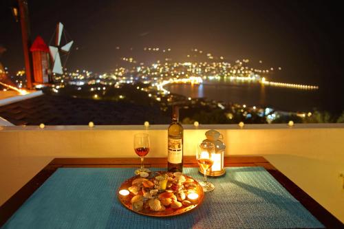 a table with a glass of wine and a plate of food at Irene' s Paradise in Skopelos Town