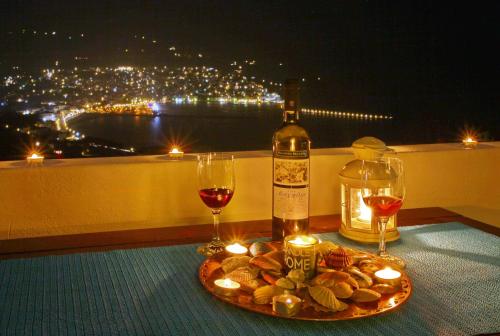 a bottle of wine and two glasses on a table at Irene' s Paradise in Skopelos Town