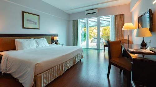 a hotel room with a bed and a desk and a bed sidx sidx sidx sidx at Mondial Hotel Hue in Hue