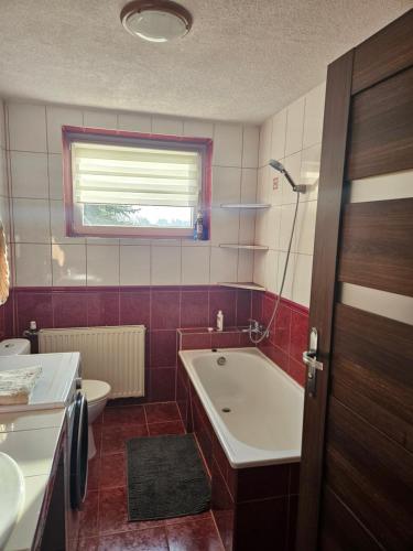 a bathroom with a tub and a toilet and a sink at Noclegi w Dolinie Baryczy in Radziądz