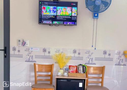 a room with two chairs and a table with a tv on the wall at KHÁCH SẠN HƯNG THỊNH - Gần biển, gần cảng khách - Trung tâm Lý Sơn in Ly Son