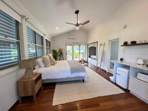 a bedroom with a bed and some windows at Bamboo Beach House & Studio in Byron Bay