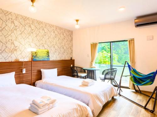 a hotel room with two beds and a hammock at ランズコンドホテル宮古島 in Miyakojima