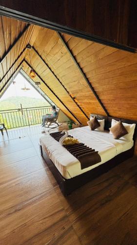 a large bed in a room with a wooden ceiling at Mountain View A frame Pool Villa in Meppādi