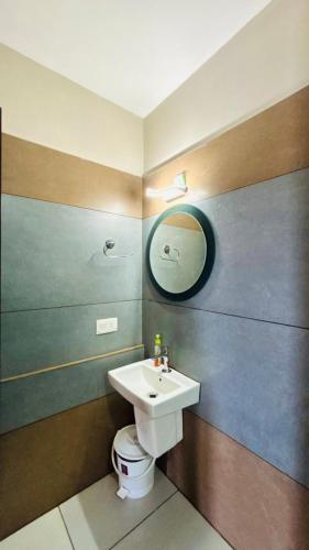 a bathroom with a sink and a toilet at Mountain View A frame Pool Villa in Meppādi