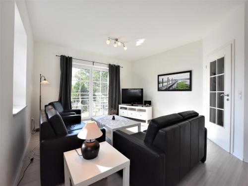 a living room with two black couches and a table at Apartment, Oldenburg in Holstein in Oldenburg in Holstein