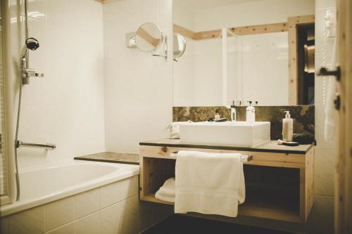 a bathroom with a sink and a bath tub and a sink at Arabella Retreat & Spa in Nauders