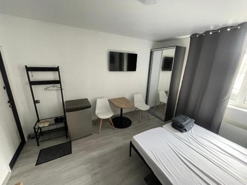 a bedroom with a bed and a table and chairs at Нові апартаменти 2 поверх, поруч лікарня та парк Феофанія, МХП in Kyiv