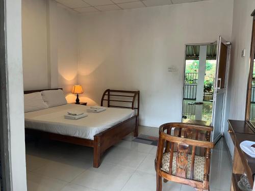 a small bedroom with a bed and a chair at Tenshin Residance. in Kandy
