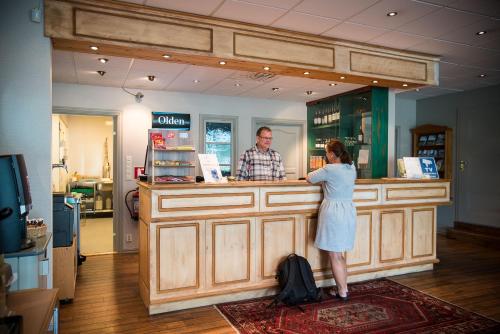 a woman standing at a counter in a store at Almaas Hotell Stord AS in Stord