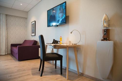 a room with a table and a chair and a couch at Almaas Hotell Stord AS in Stord