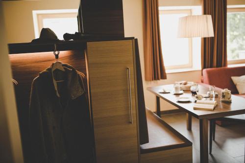 a hotel room with a cabinet with a table and a room at Arabella Retreat & Spa in Nauders