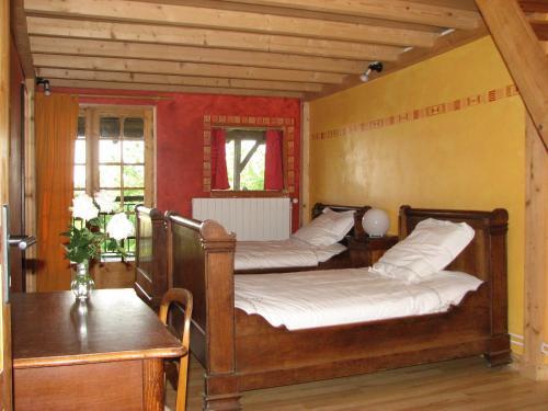 a bedroom with two beds and a table and a window at Gîte les Peyrets in Montech