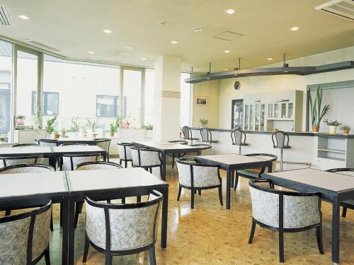 restauracja ze stołami i krzesłami w pokoju w obiekcie Hotel Sunfuraton w mieście Furano