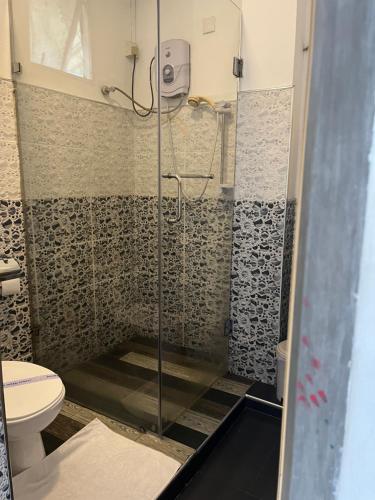 a shower in a bathroom with a toilet at Tenshin Residance. in Kandy