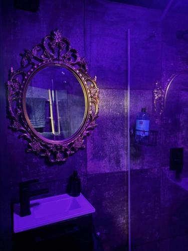 a purple bathroom with a mirror and a sink at Love room location de 15h a 17h in Wattignies