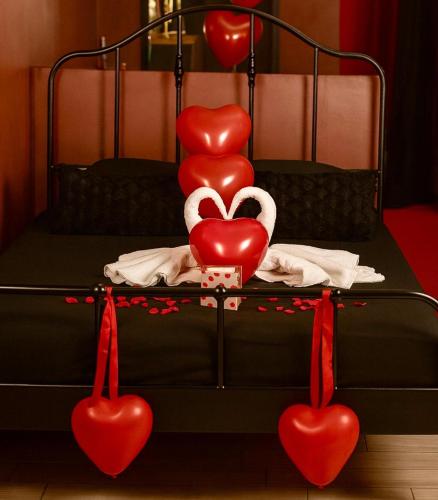 a bed with red hearts on top of it at Love room location de 15h a 17h in Wattignies