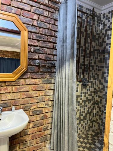 a brick bathroom with a sink and a shower at 5 Moepel in Potchefstroom