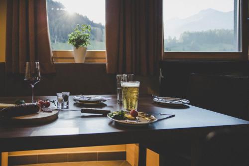 a table with plates of food and a glass of beer at Arabella Retreat & Spa in Nauders