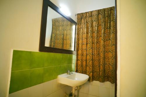 a bathroom with a sink and a mirror at Hotel Raaj Bhaavan - US Consulate - Nungambakkam in Chennai
