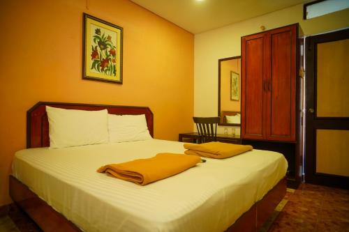 a bedroom with a bed with two towels on it at Hotel Raaj Bhaavan - US Consulate - Nungambakkam in Chennai