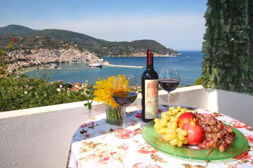 a table with a plate of fruit and a bottle of wine at Irene' s Paradise in Skopelos Town