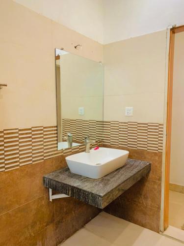 a bathroom with a white sink and a mirror at Hazelton in Islamabad