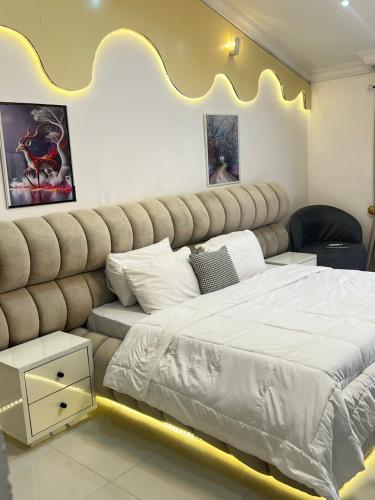a bedroom with a large bed with a large headboard at ShowLove Luxury Apartment in Lekki Phase 1