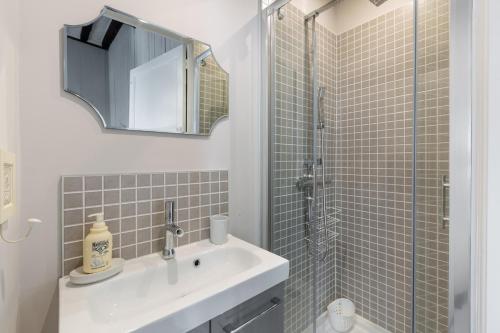 une salle de bain avec un lavabo et une douche avec un miroir dans l'établissement Ty Sauveur by Cocoonr, à Rennes