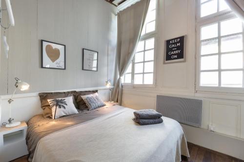 a bedroom with a large bed and two windows at Ty Sauveur by Cocoonr in Rennes