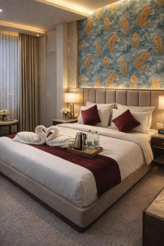 a bedroom with a large bed with a painting on the wall at Hotel Alpine in Indore