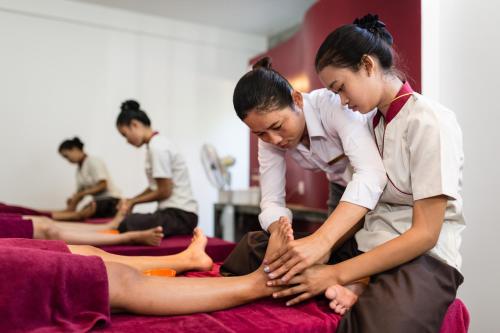 a group of people sitting on a bed with their legs at Sala Baï Hotel & Restaurant School in Siem Reap