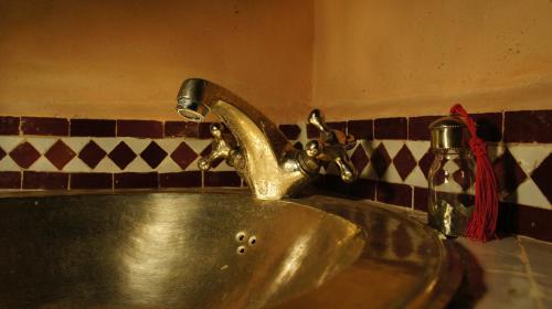 a bathroom sink with a metal faucet at Riad Jardin des Orangers in Taroudant