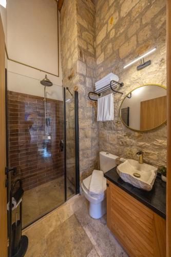 a bathroom with a shower and a toilet and a sink at Atrium Suites Taş Konak in Urla