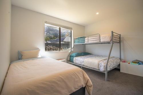 a bedroom with two bunk beds and a window at Hāwea Home Haven in Lake Hāwea