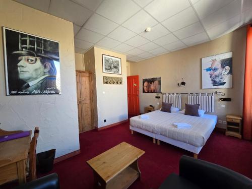 a bedroom with a bed and a large poster of a man at Hôtel Le Colbert in Avignon