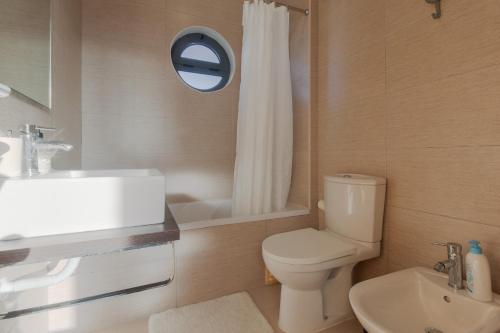 a bathroom with a white toilet and a sink at Villa 4 Rooms, Swiming Pool Pink in Palmela