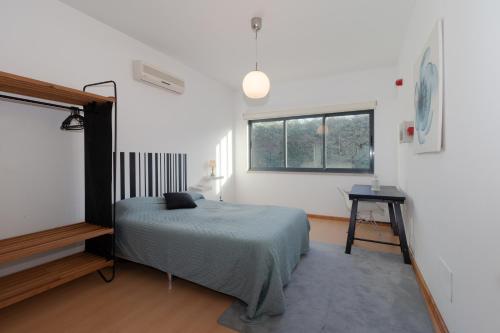 a bedroom with a bed and a window at Villa 4 Rooms, Swiming Pool Pink in Palmela