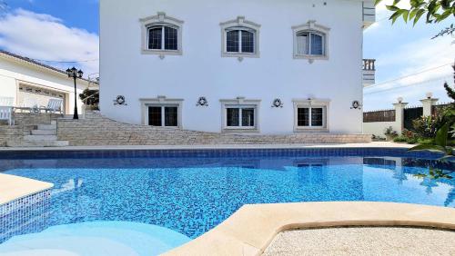a large swimming pool in front of a white house at Silver Coast Pool & Resort Villas in Arnal