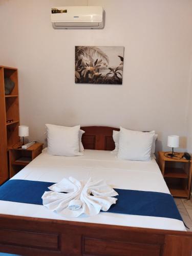 a bedroom with a bed with towels on it at Auberge de l'hippocampe in Moroni