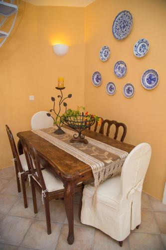 a dining room table and chairs with plates on the wall at Lydia Luxury villa in Karterados
