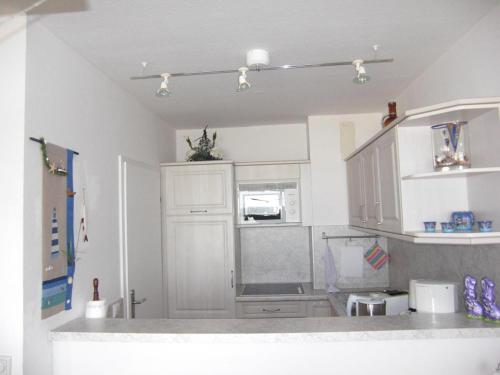 a kitchen with white cabinets and a counter top at Strandhotel Wohnung 28 in Dahme