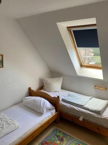 two twin beds in a room with a window at Saarstrasse 18h in Dahme