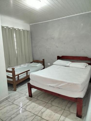 a bedroom with two beds and a window in it at Casa com piscina Ana Eliza in Cambé